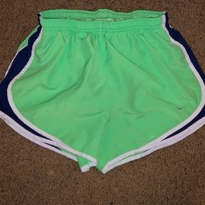 Neon green Nike shorts with white and blue strip